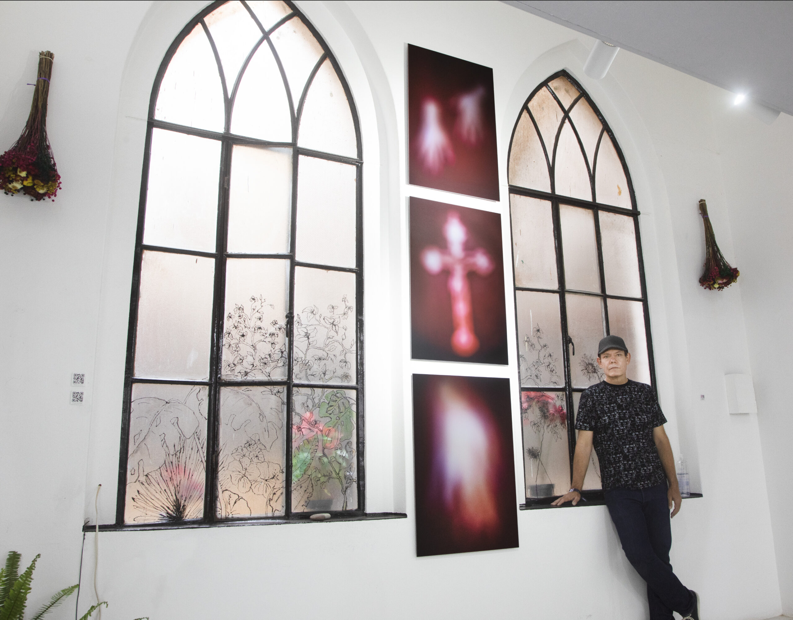 Chapel windows interior with white walls marooc red vertical image floor to ceiling hang between the windows. Showing the hands of God, A crucific and the holy spirit form or shape. 