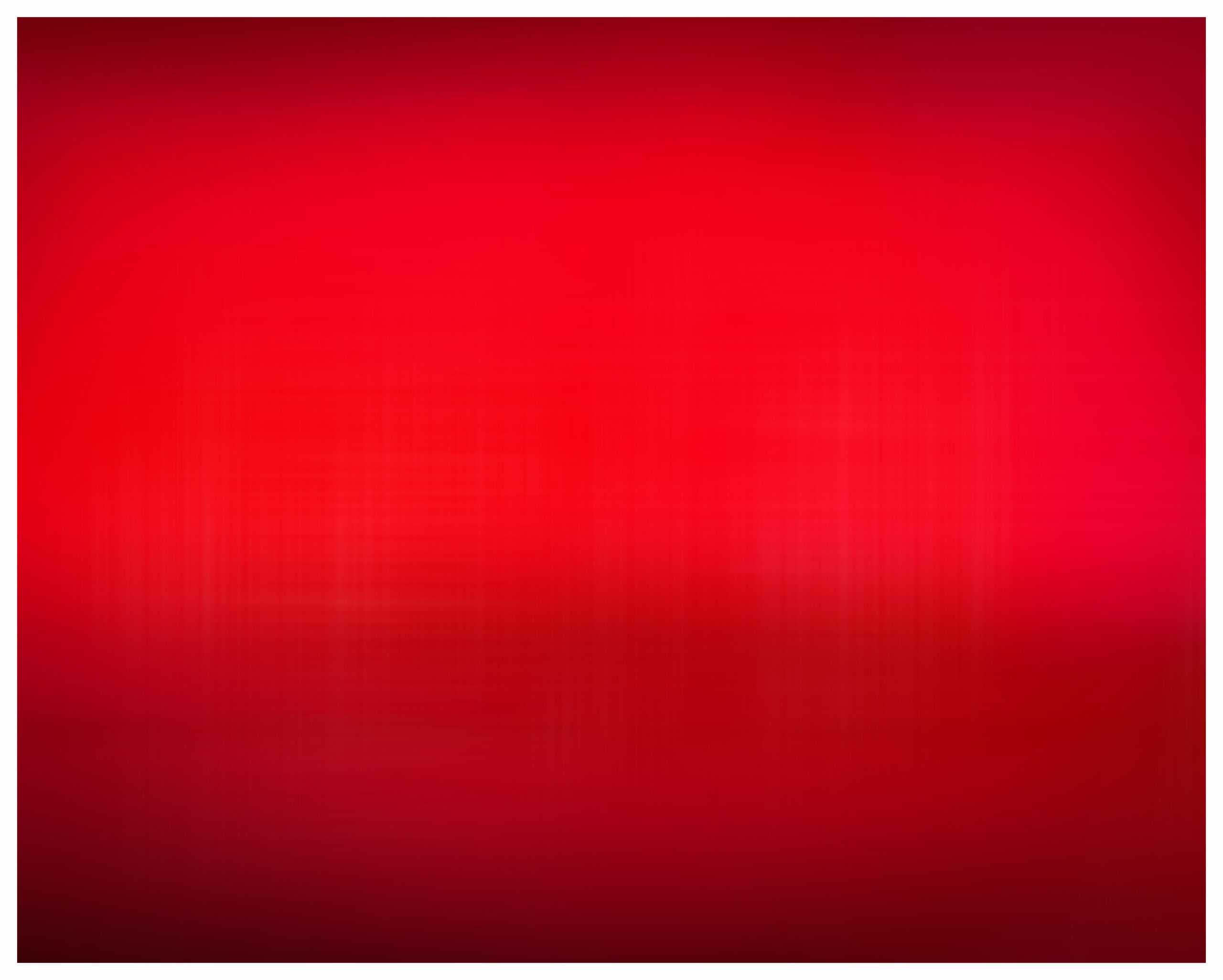 Blurry horizontal photo with multiple shades of red on a color field of red