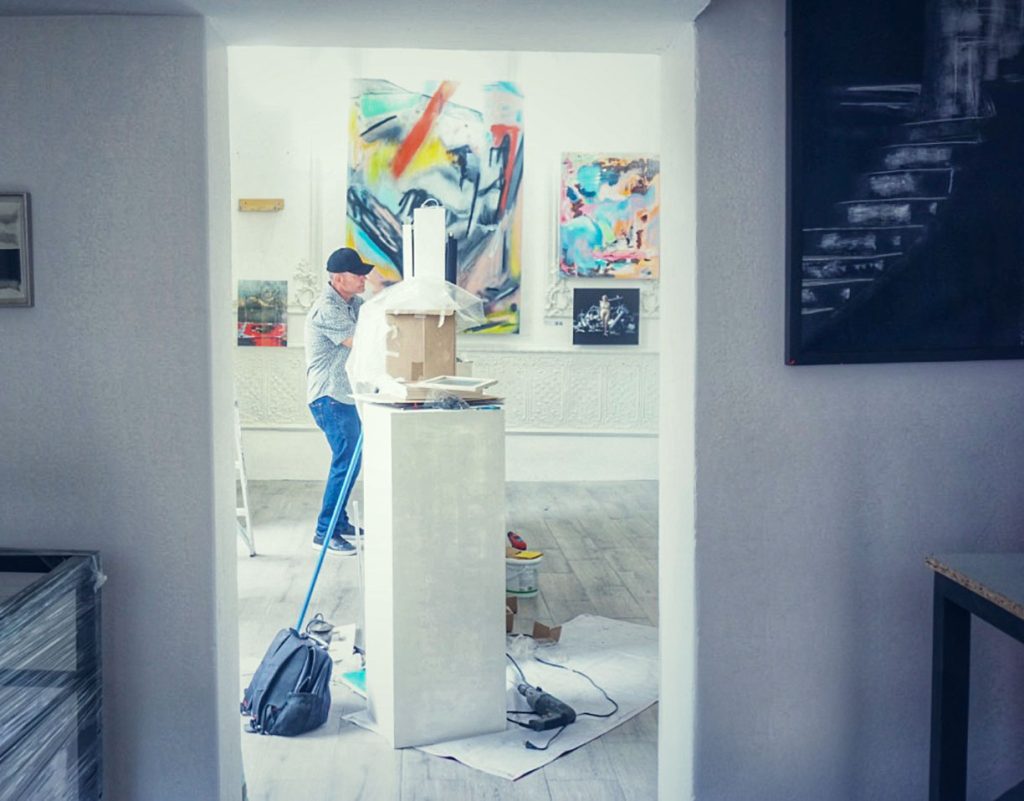 Doug Winter installing artwork in a gallery.
